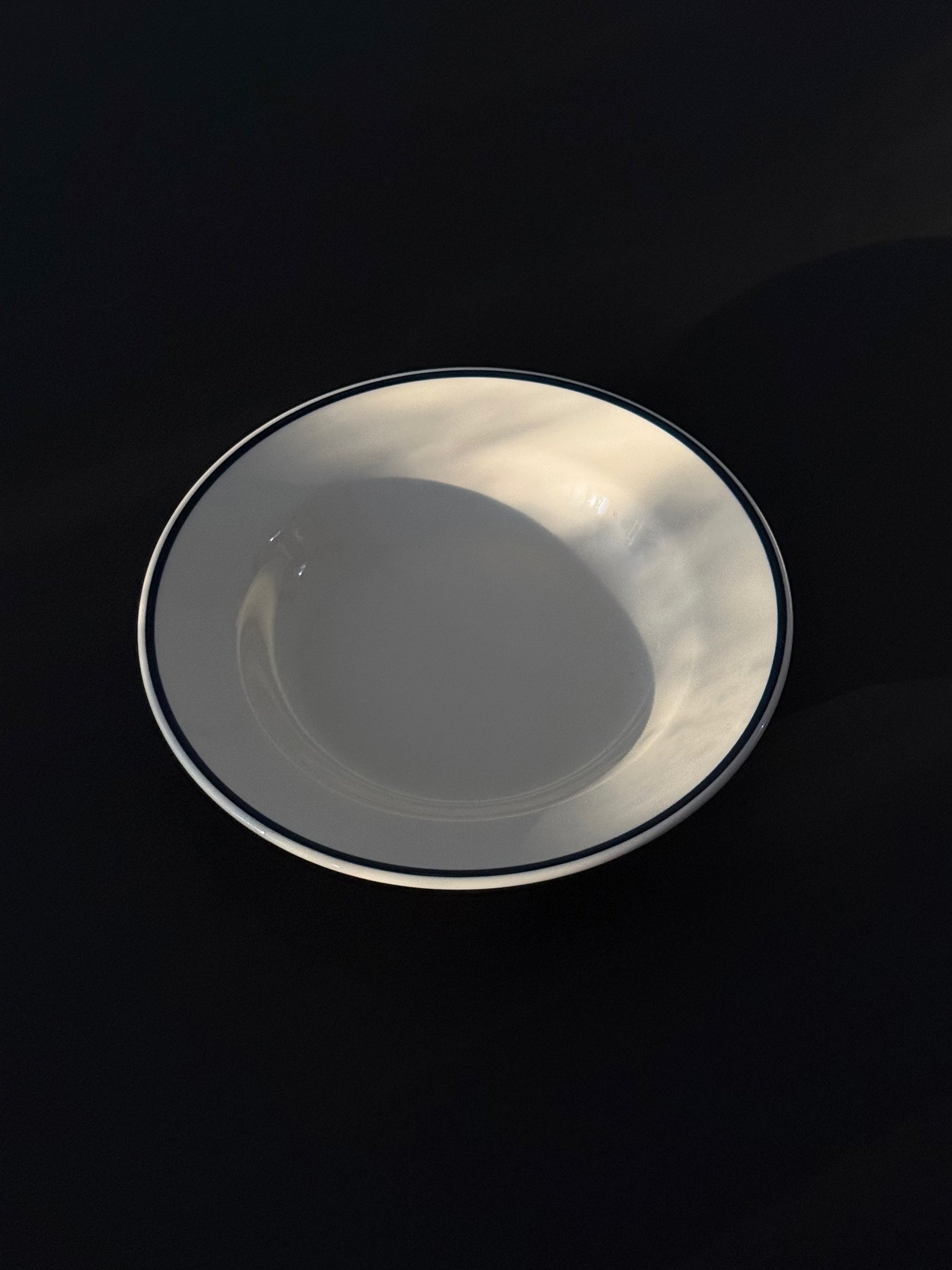 Sunlit Tuxton Blue Line deep rim soup plate in eggshell white with hand-painted blue band.