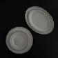 Tuxton Charleston round dinner plates and oval platters in American White with embossed scalloped edges.