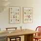 A lifestyle photo of art print A Collection of Chairs by Isabelle Vandeplassche, exclusively for The Poster Club, in a light wooden frame, paired with the art print A Collection of Lamps. 
