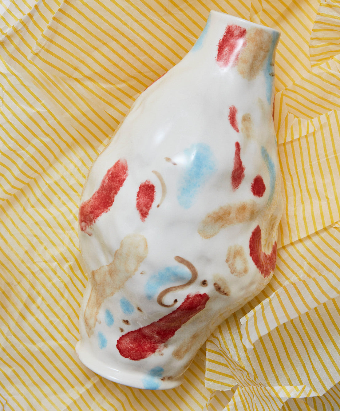 A close-up view of the HAY Jessica Hans stoneware vase in the Miro colorway, showcasing its deliberately uneven, organic shape and hand-painted, abstract multicolored pattern.