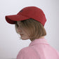 Side view of a woman wearing HÔTEL827 Sun Kissed baseball cap in chilli paring with pink top. 