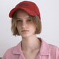 A woman HÔTEL827 Sun Kissed baseball cap in chilli paring with pink top. 