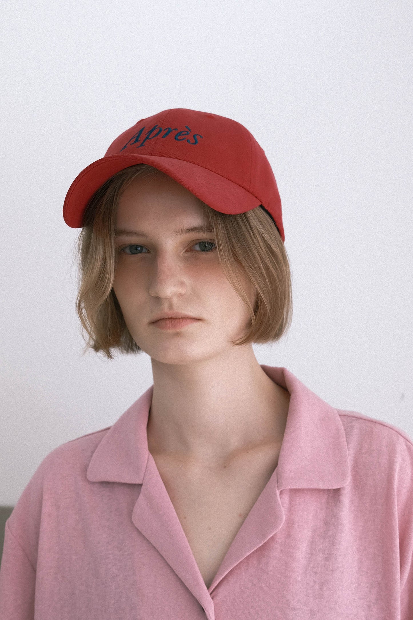 A woman HÔTEL827 Sun Kissed baseball cap in chilli paring with pink top. 