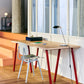 Hay Apex Desk lamp in iron black on a wooden desk.