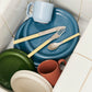 Hay Barro plates stacked in sink.