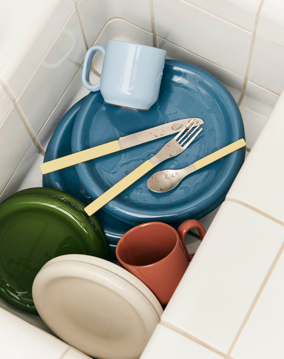 Hay Barro plates stacked in sink.