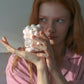 Person holding HÔTEL827 pink glass storage jar containing make up cotton balls.