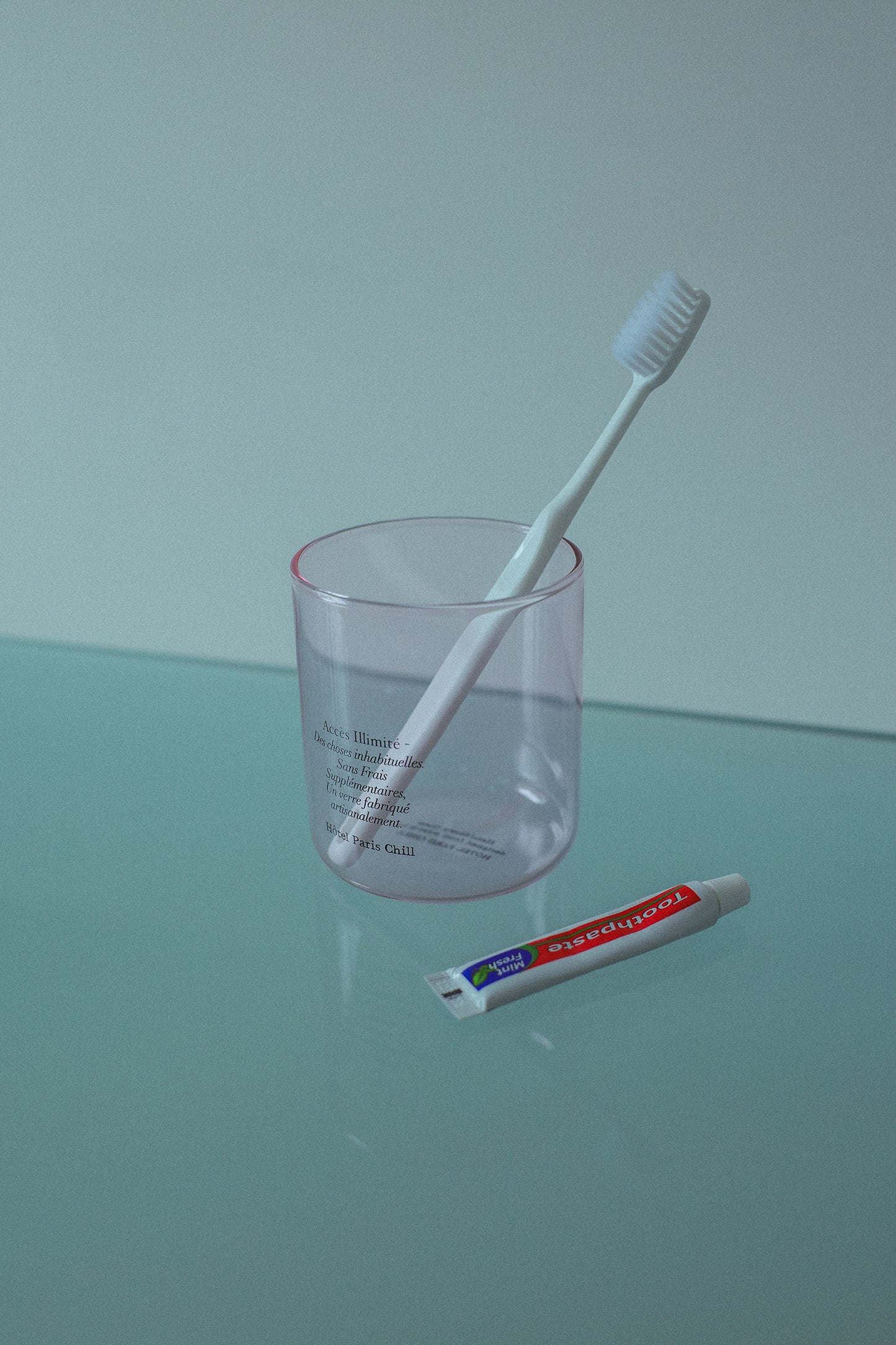 HÔTEL827 pink glass storage jar on table used as as toothbrush holder.
