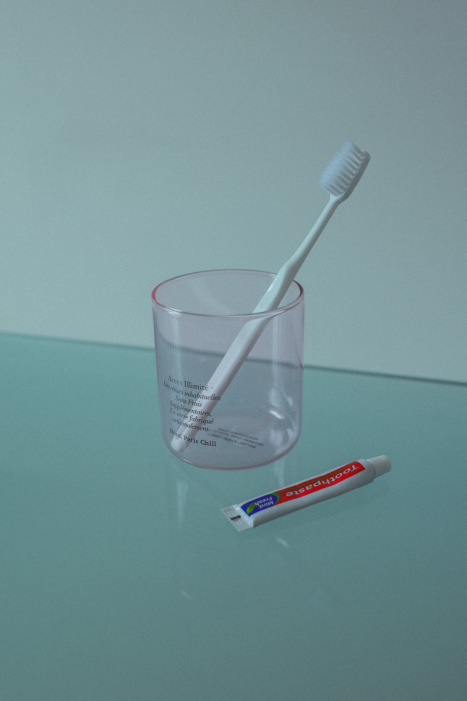 HÔTEL827 pink glass storage jar on table used as as toothbrush holder.