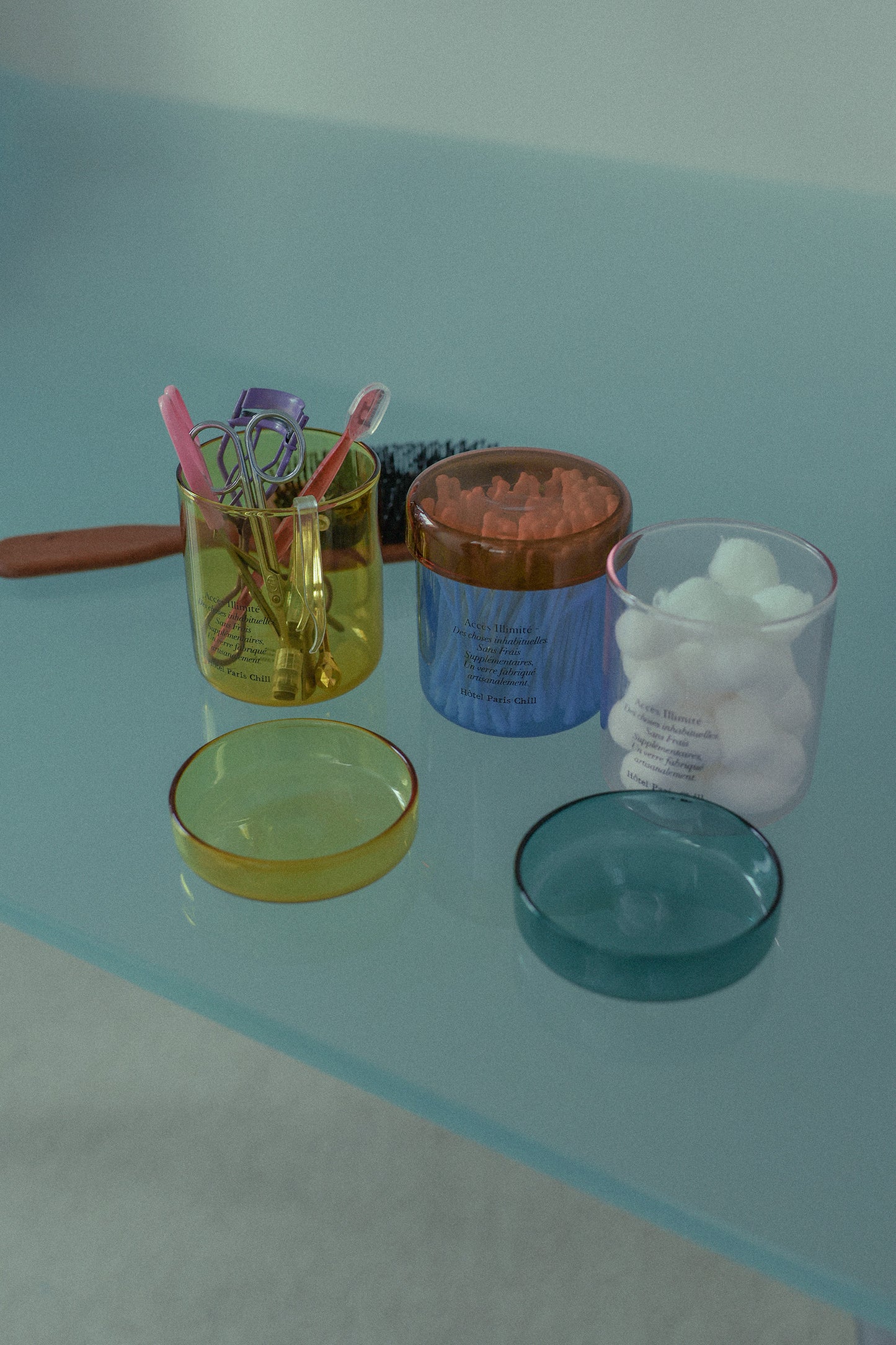 HÔTEL827 glass storage jars on vanity holding cotton pads and accessories
