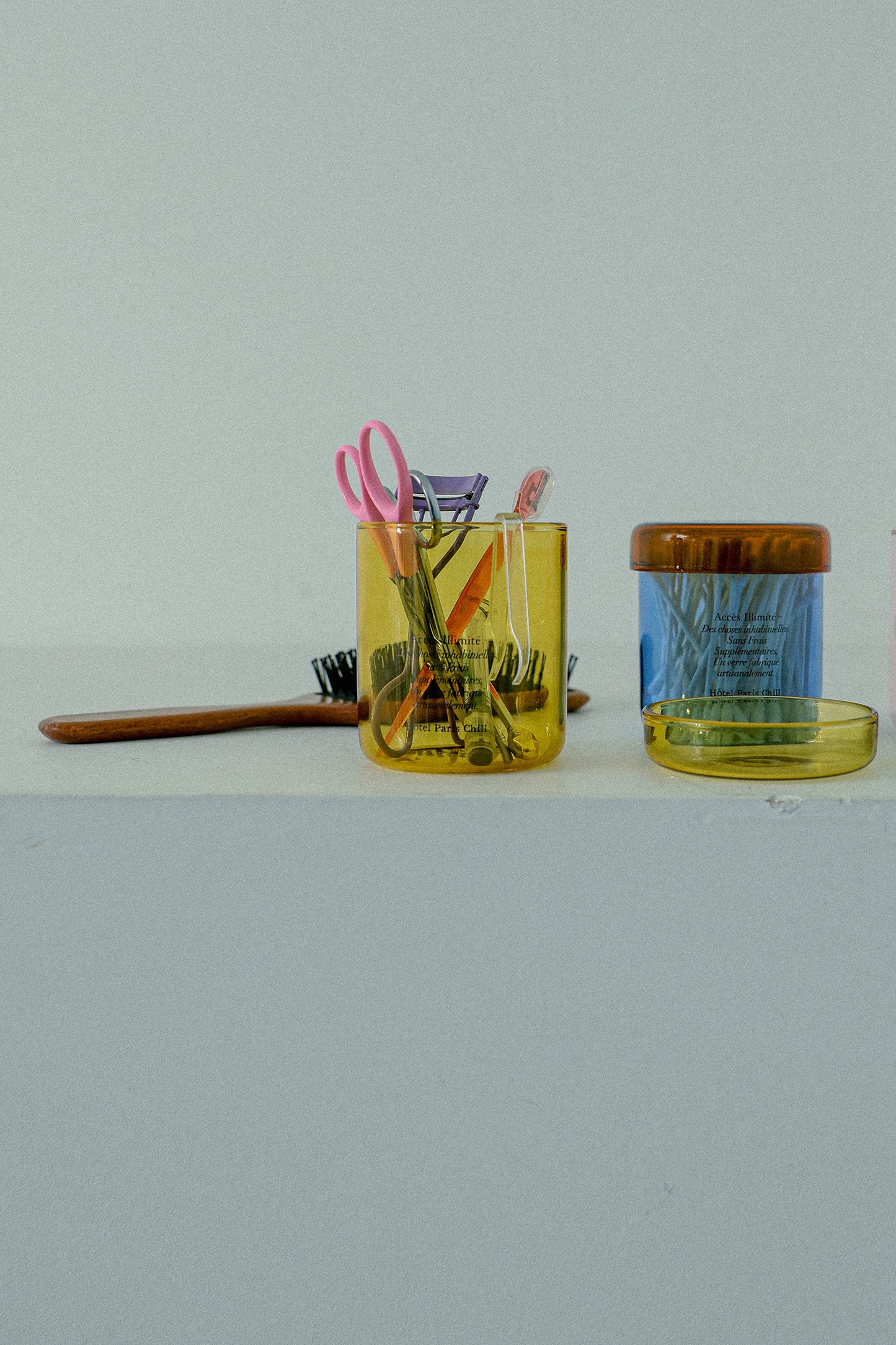 HÔTEL827 blue glass storage jar on vanity table holding cotton pads and accessories