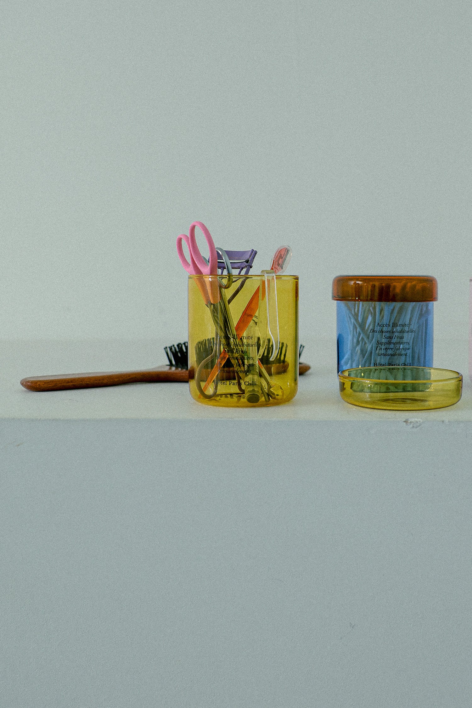 HÔTEL827 blue glass storage jar on vanity table holding cotton pads and accessories