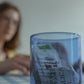 Close-up of HÔTEL827 blue glass storage jar on dining table holding tea bags.