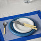 Table setting with Hay 18cm Barro plates in dark blue and off-white on a white tablecloth.