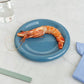 Hay Barro Plate 18cm in Dark blue, serving a prawn. 