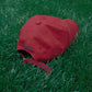Back of HÔTEL827 Sun Kissed baseball cap in chilli on the grass.