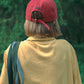 Back view of Model wearing HÔTEL827 Sun Kissed Chilli red cotton baseball cap outdoor