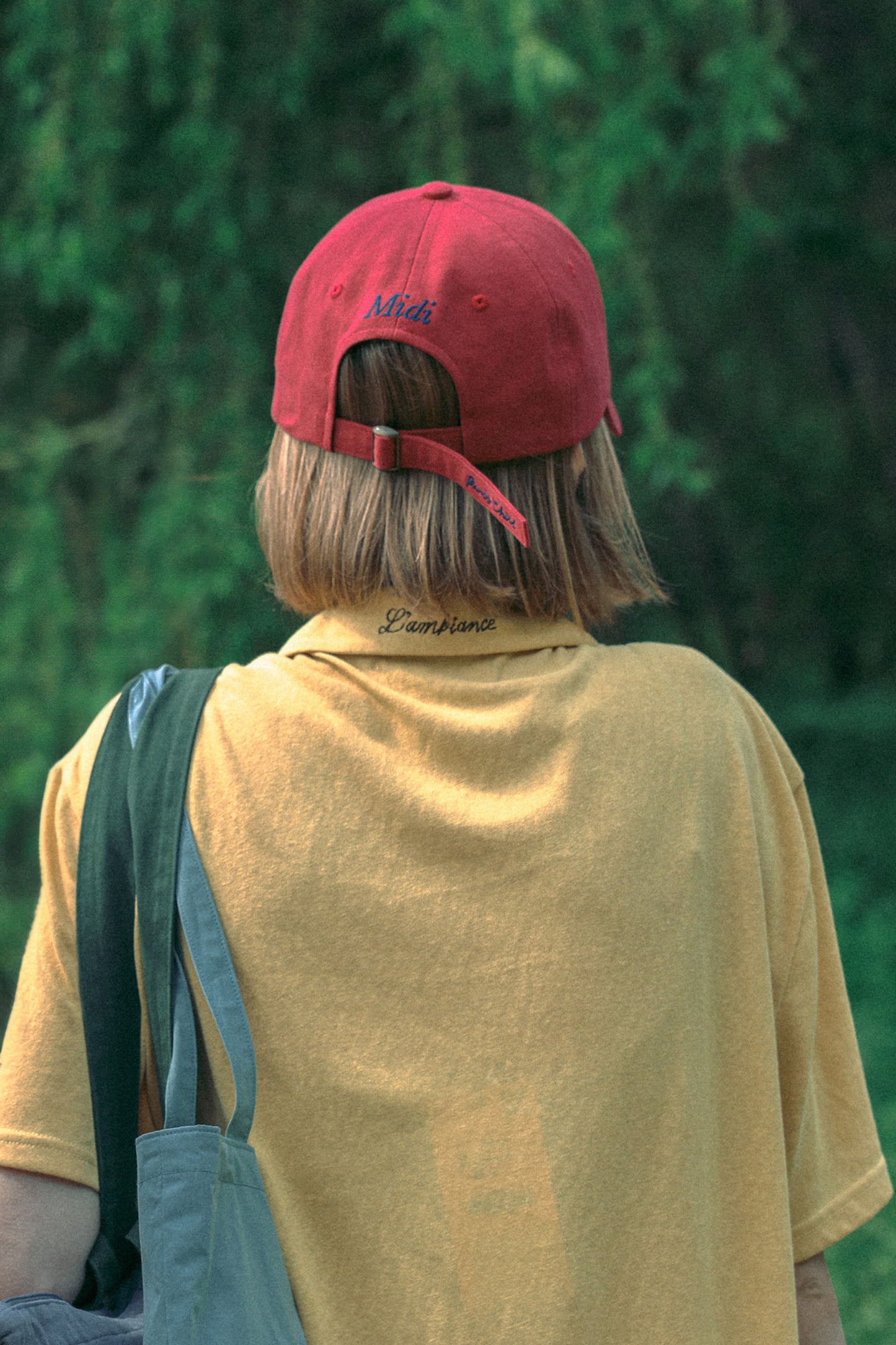 Back view of Model wearing HÔTEL827 Sun Kissed Chilli red cotton baseball cap outdoor