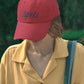 Model wearing HÔTEL827 Sun Kissed Chilli red cotton baseball cap outdoor