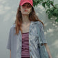 A woman wearing HÔTEL827 Sun Kissed baseball cap in chilli colour, with casual street wear.