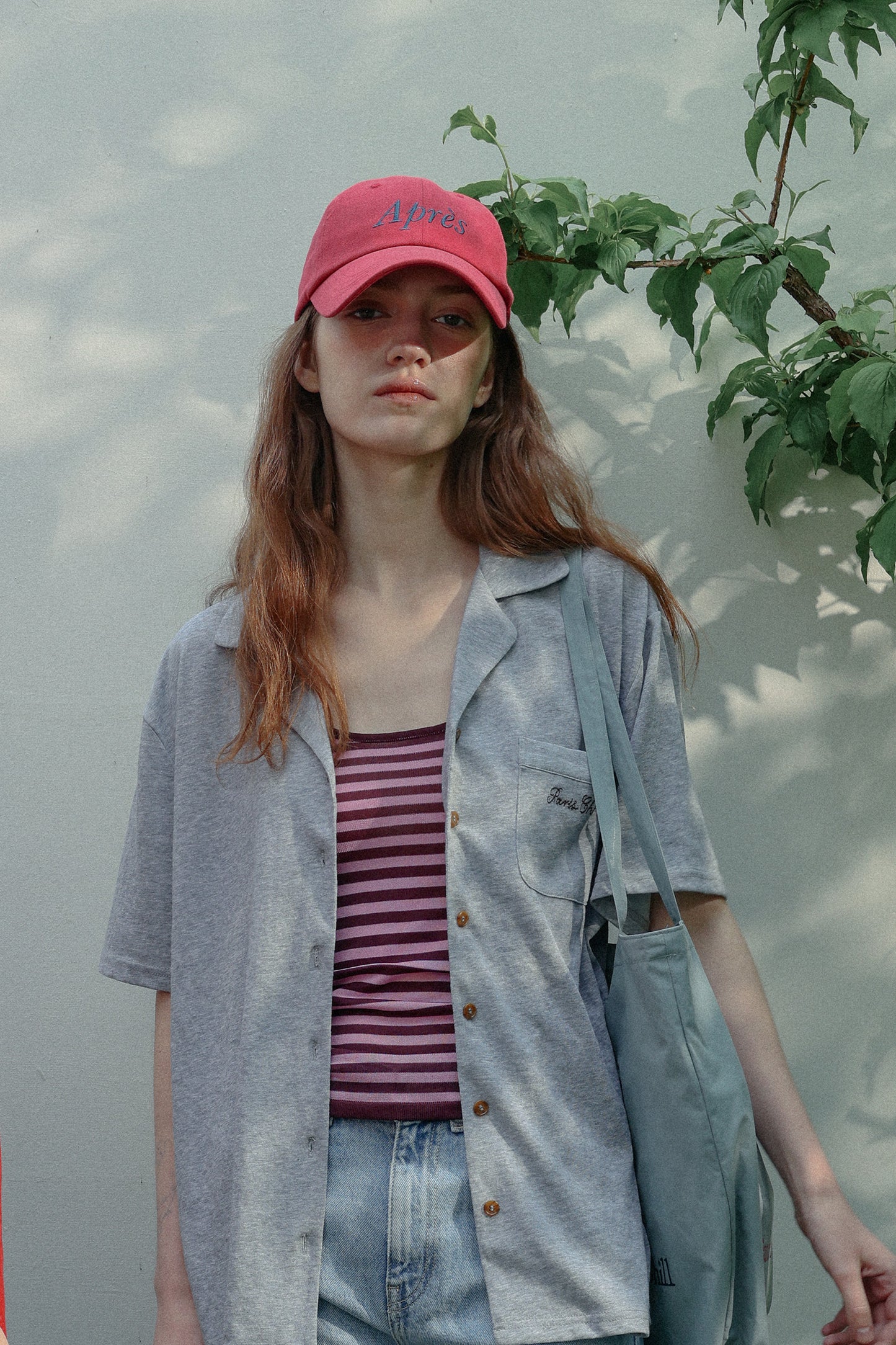 A woman wearing HÔTEL827 Sun Kissed baseball cap in chilli colour, with casual street wear.