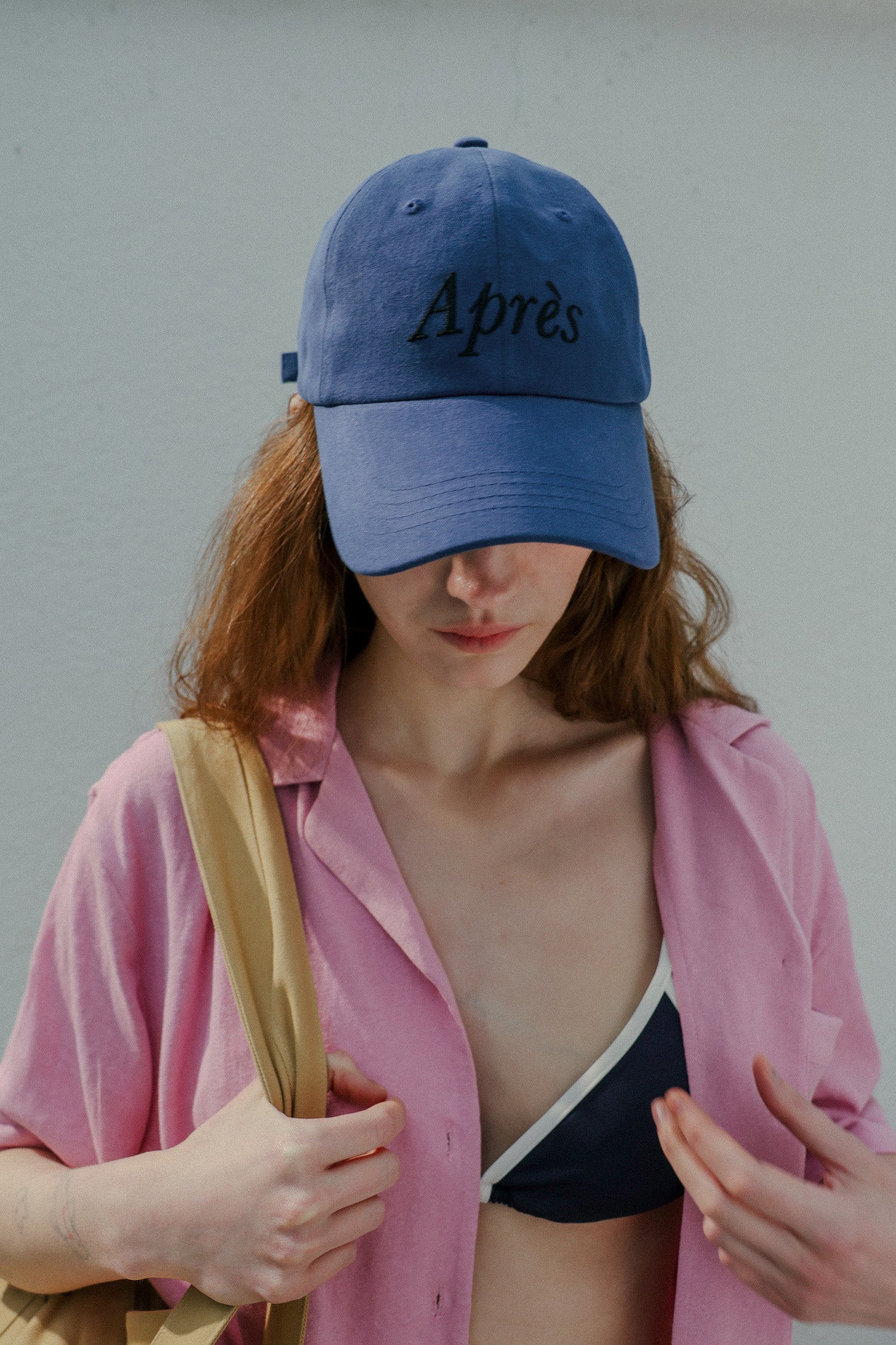 Woman wearing HÔTEL827 Sun Kissed blue baseball cap in beach wear. 