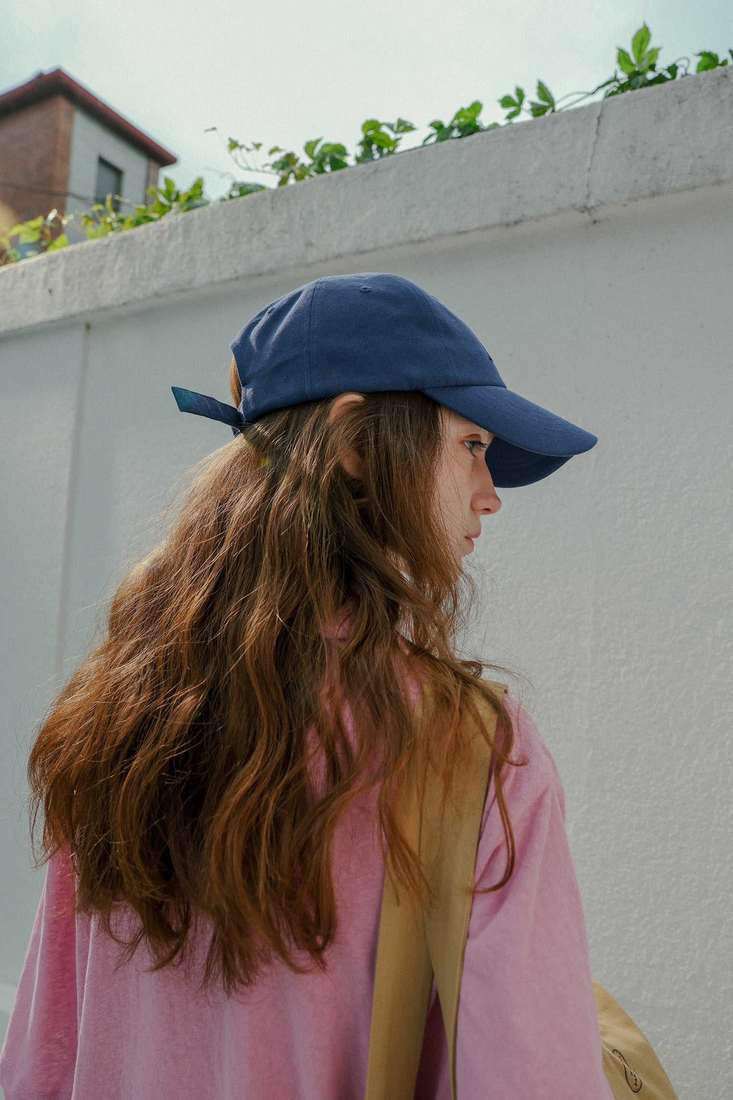 Side angle of Woman wearing HÔTEL827 Sun Kissed blue baseball cap in casual street style