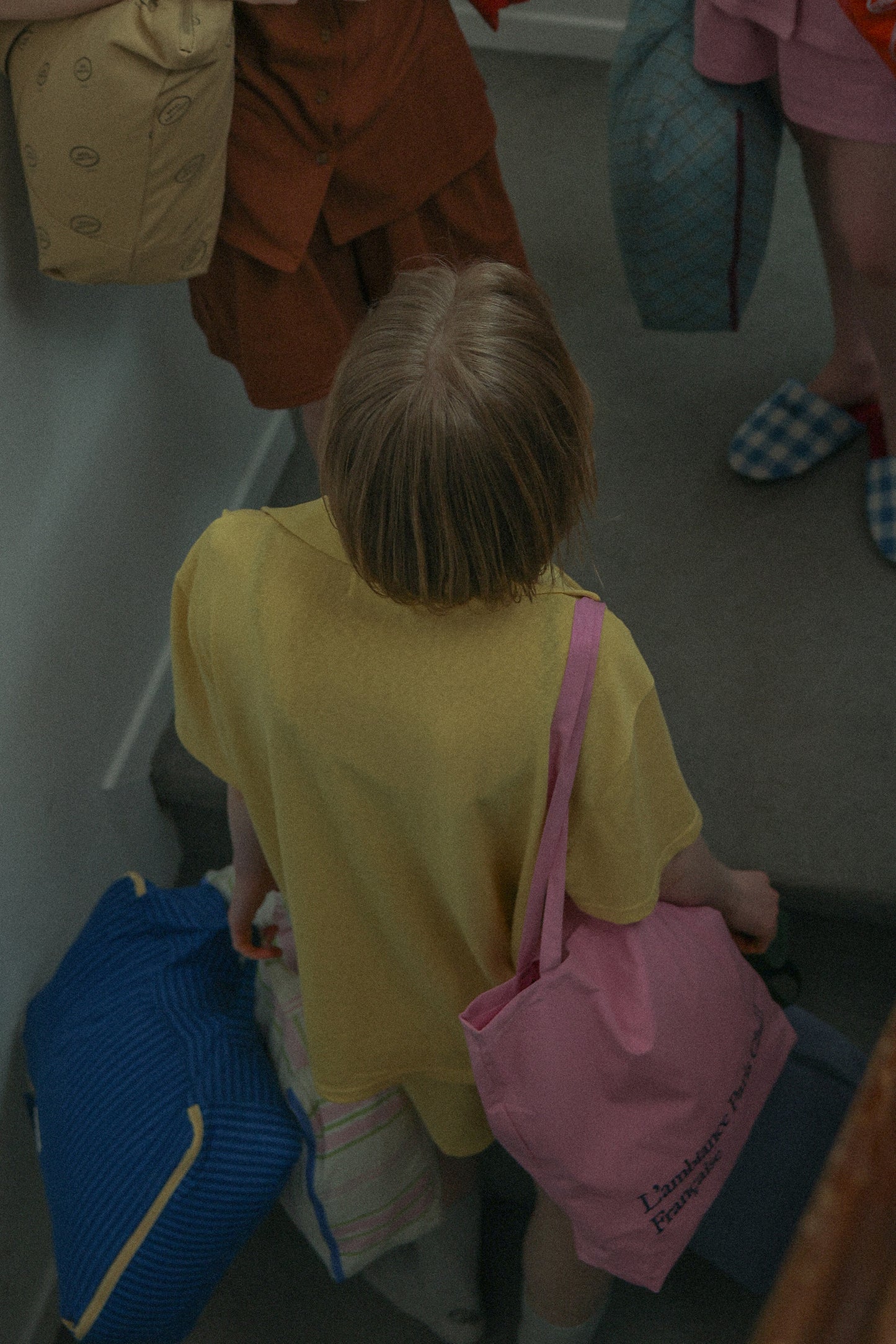 A woman wearing yellow pyjamas, wearing HÔTEL827 Sun Kissed pink canvas tote bag over shoulder