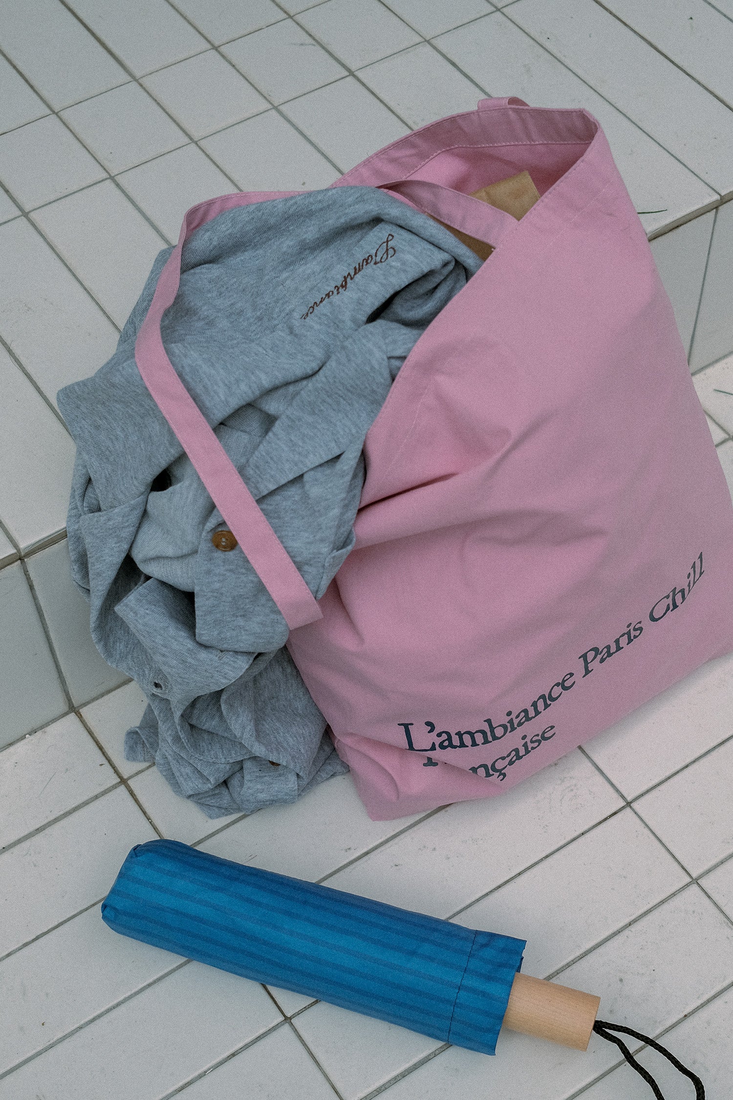 HÔTEL827 Sun Kissed pink canvas tote bag nearby a swimming pool.