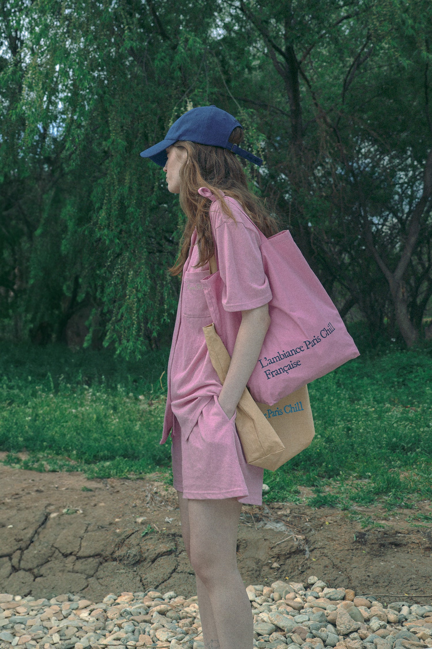 A woman wearing a pink casual wear set, wearing HÔTEL827 Sun Kissed pink canvas tote bag over shoulder