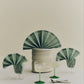 A lifestyle shot of  two HAY Tint Wine Glasses, showcasing minimalist clear borosilicate glass bowls resting on delicate stems in jade light green and jade dark green.