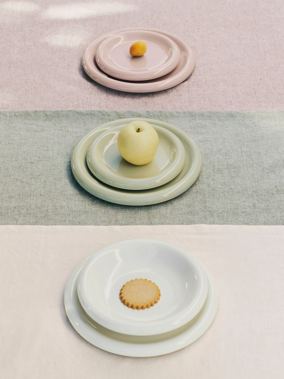 Stack of Hay barro plates with fruits on a pastel-colored surface