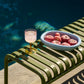 HAY Barro light blue terracotta oval dish with peaches on a outdoor chair near the pool.