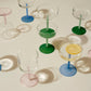 A shot of HAY Tint Wine Glasses, showcasing their minimalist clear borosilicate glass bowls resting colourful stems.
