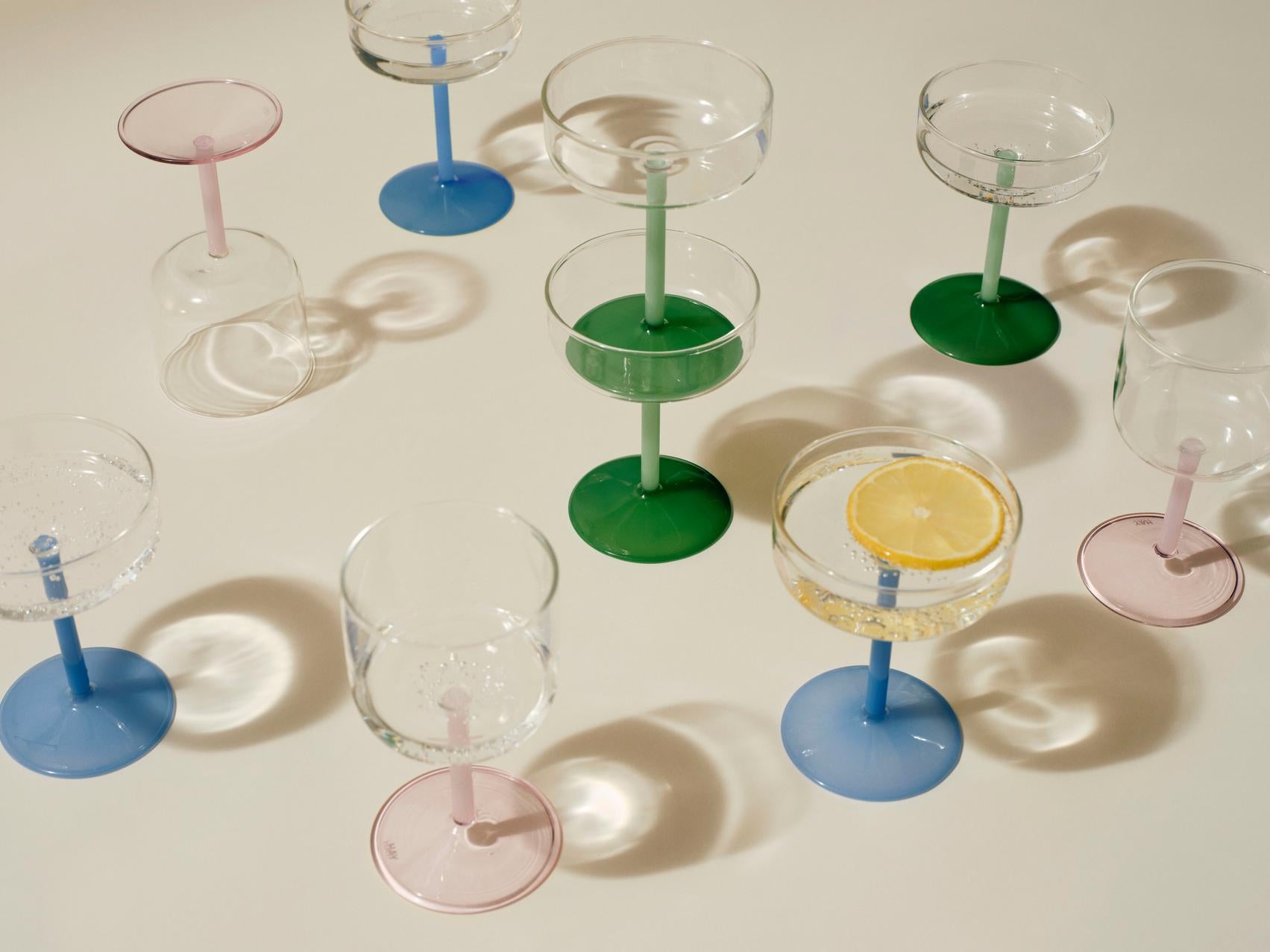 A shot of HAY Tint Wine Glasses, showcasing their minimalist clear borosilicate glass bowls resting colourful stems.