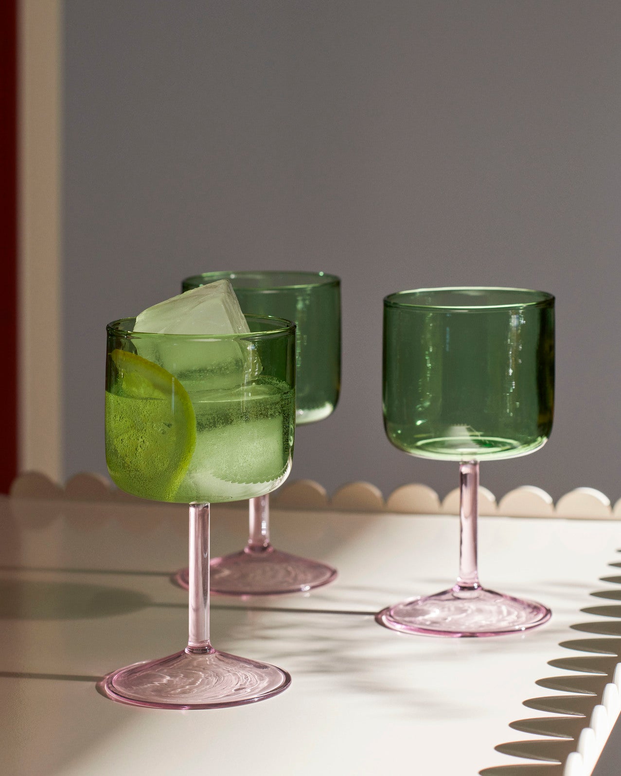 A close up shot of the set of two HAY Tint Wine Glasses in Green and Pink.