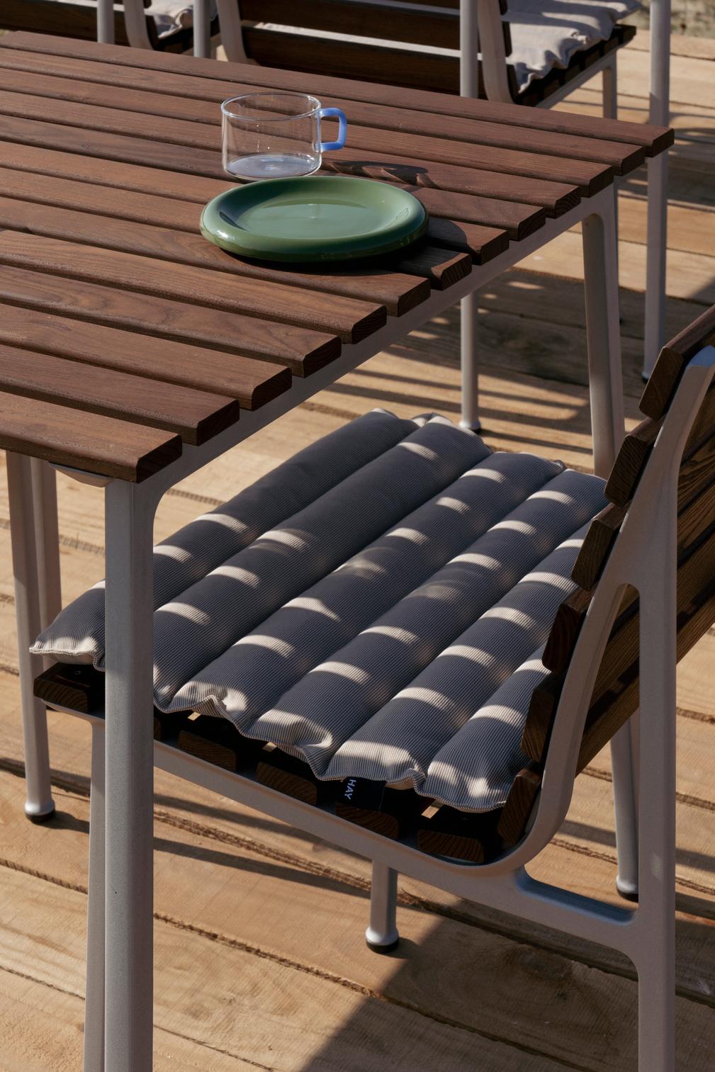 Hay Barro Plate 18cm in Green on a wooden outdoor table. 