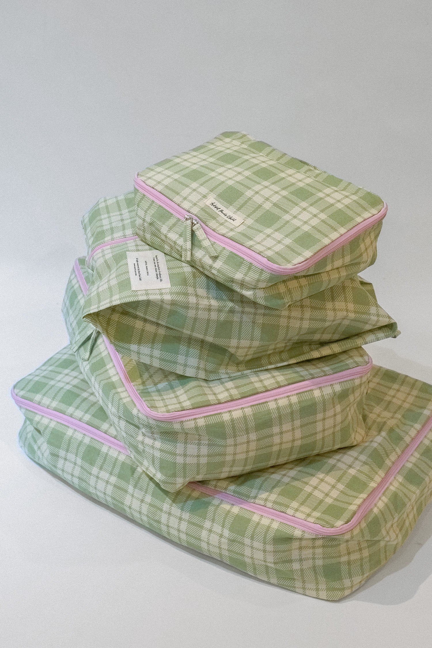 A Stack of Hotel827 Cotton Travel Pouch in Evergreen in different sizes. 