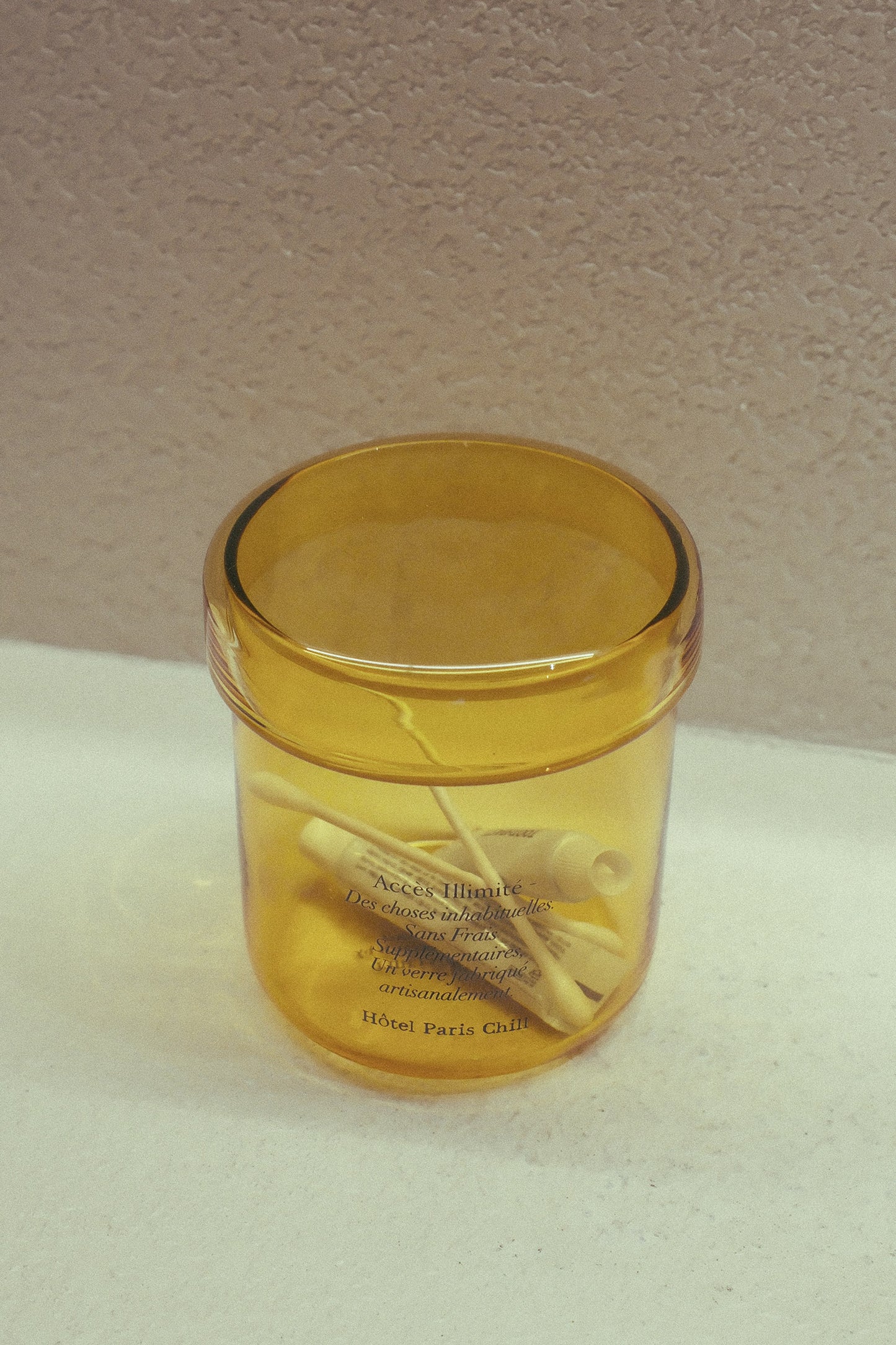 Colour match of HÔTEL827 Overhaze Vanilla mouth blown borosilicate glass jar container with yellow lid.