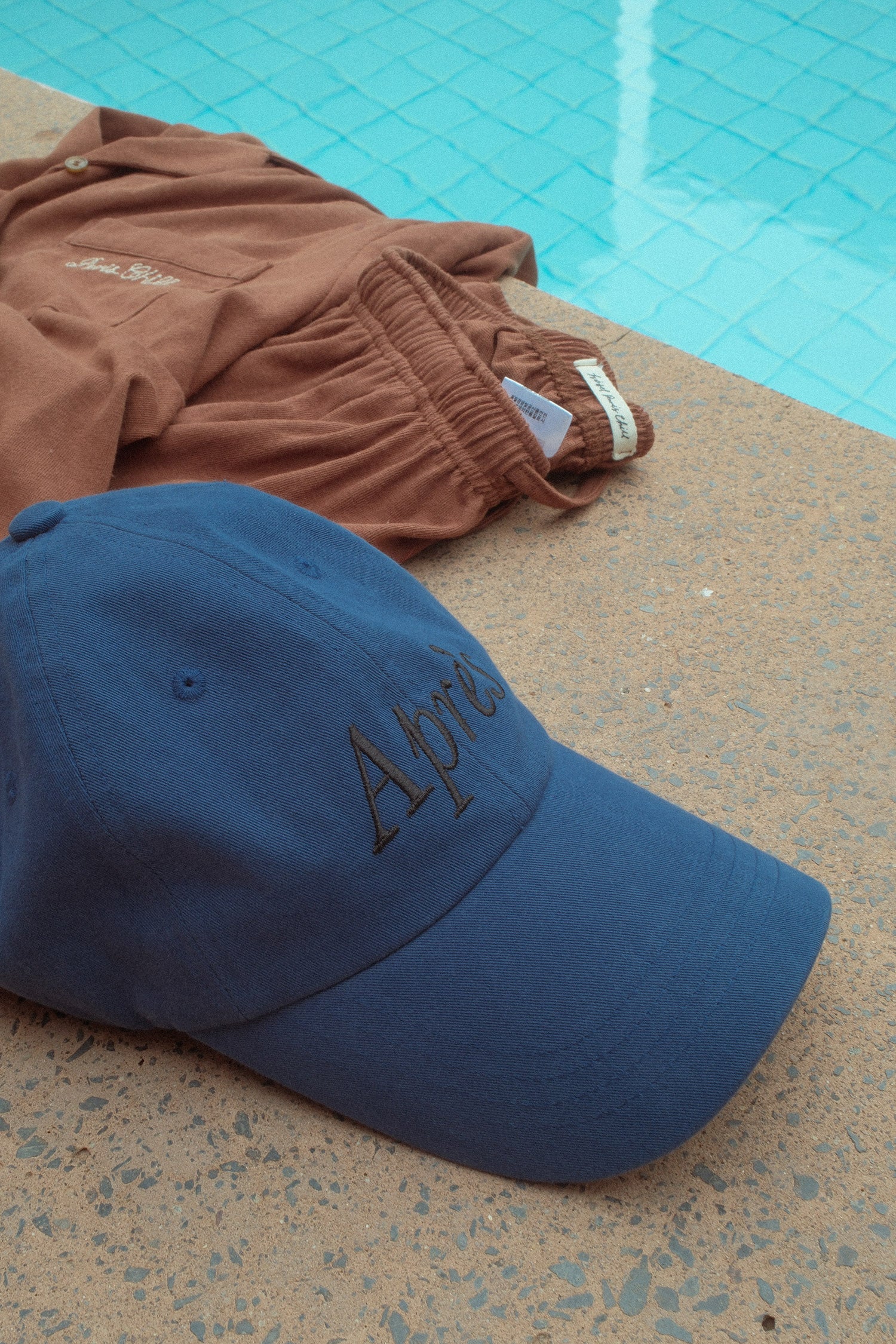 HÔTEL827 Sun Kissed blue baseball cap nearby a pool.