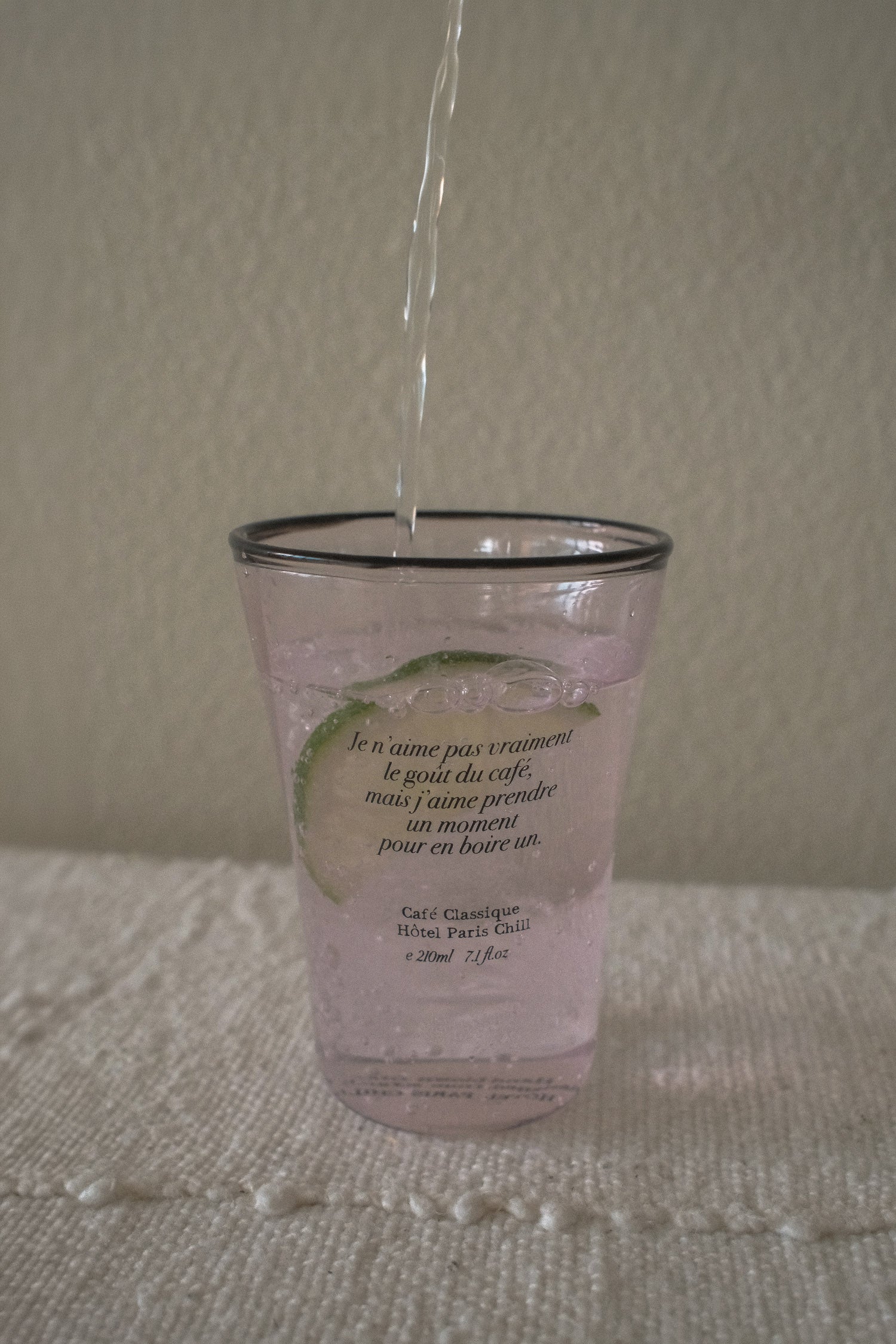 Iced drink served in HÔTEL827 Sun Kissed blush pink glass tumbler on styled dining table