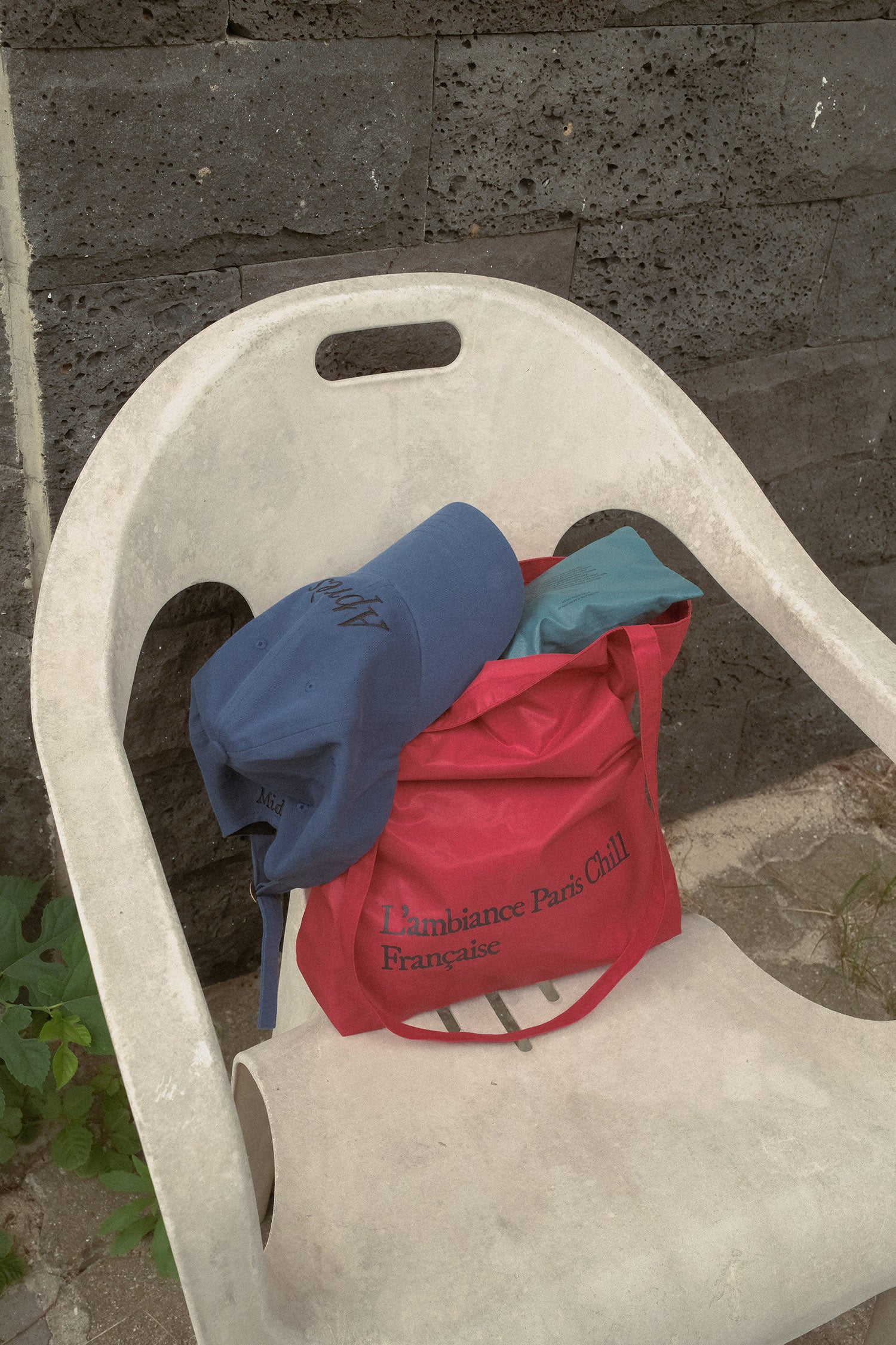 HÔTEL827 Sun Kissed blue baseball cap on top of Hotel827 sun kissed bag in red. 