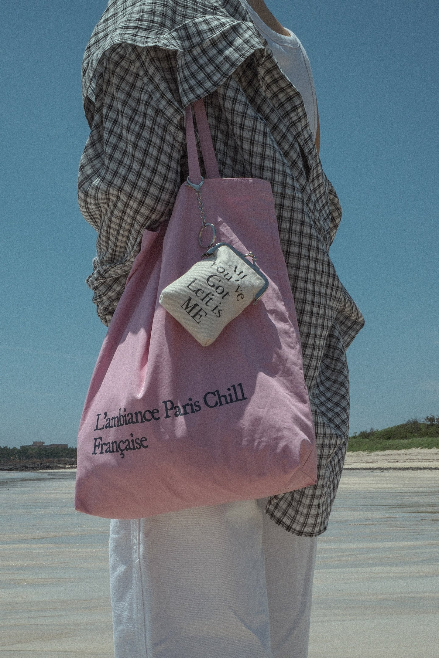 Woman wearing HÔTEL827 Sun Kissed pink canvas tote bag over shoulder pairing with a Hotel827 coin pouch.
