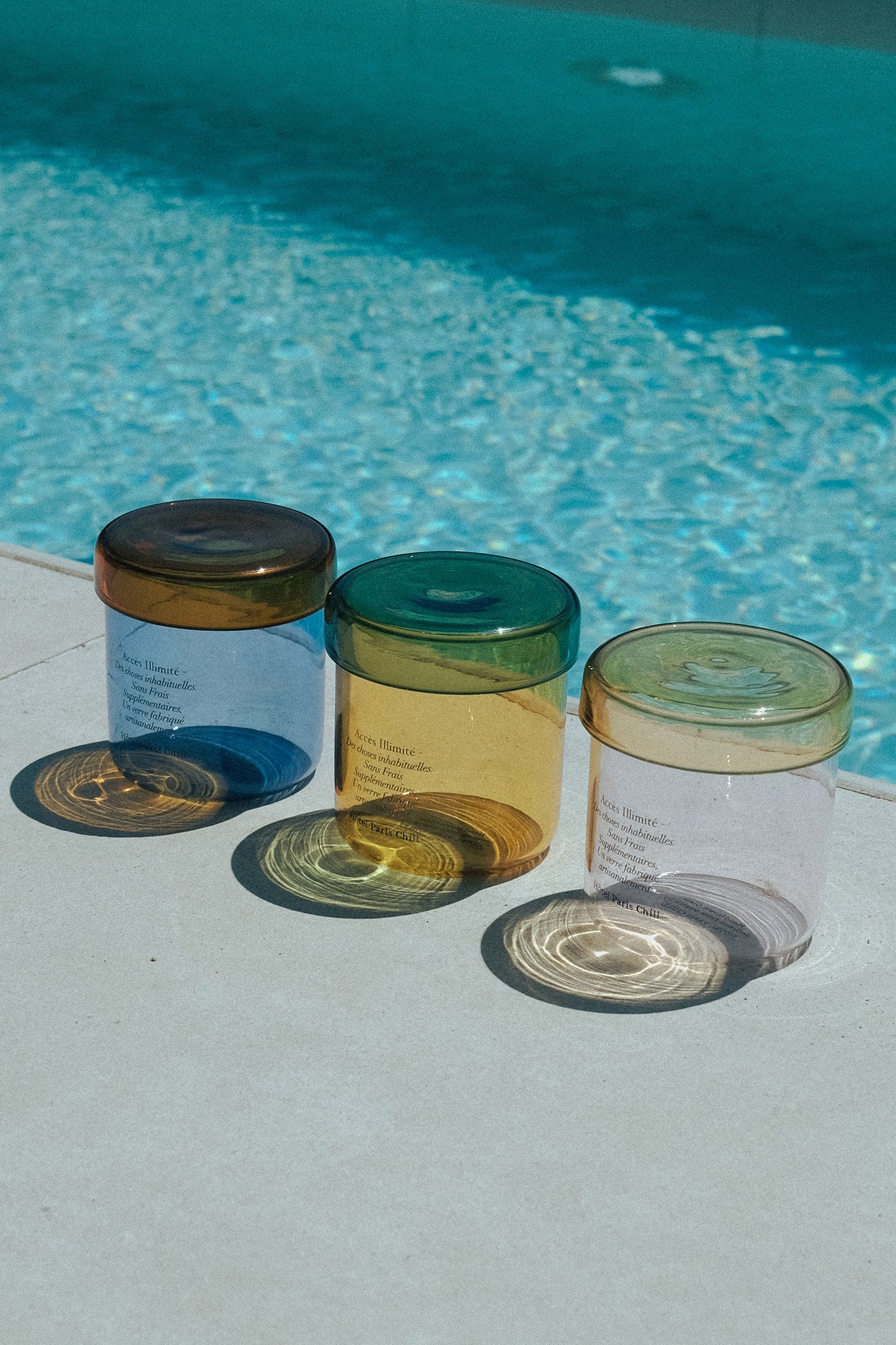 HÔTEL827 glass storage jars nearby a swimming pool.