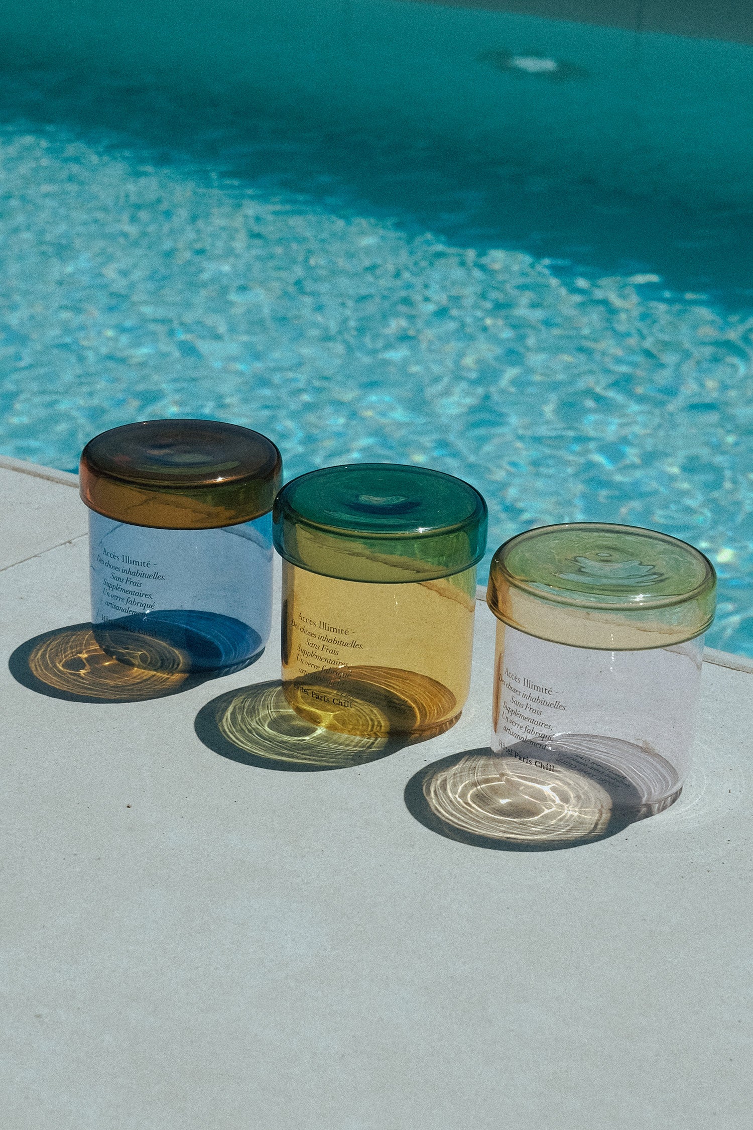 HÔTEL827 glass storage jars nearby a swimming pool.