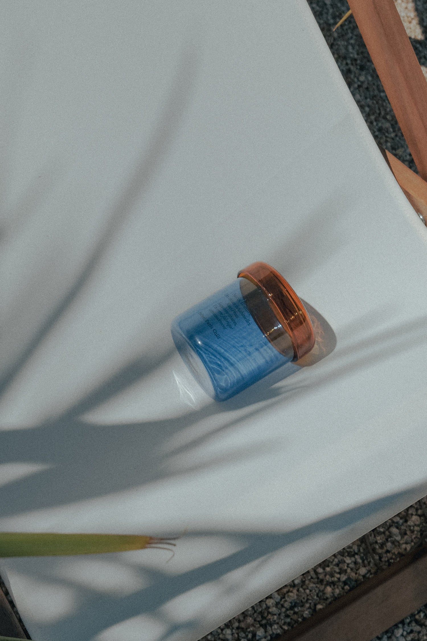 HÔTEL827 blue glass storage jar on an outdoor chair.