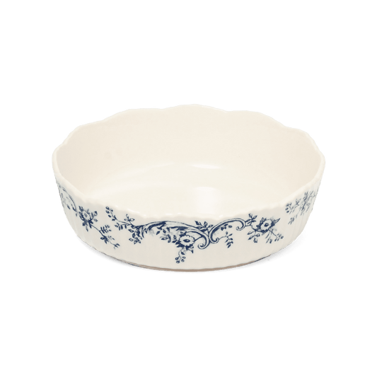 A pack shot of Studio M' Audrey Cake Pan in indigo colour, featuring a scalloped lace-like rim and an English garden-inspired floral relief pattern.