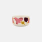Side-angle view of the Marimekko Oiva 500ml white stoneware bowl featuring the Kukasta Kukkaan abstract floral and leaf pattern in pink, terracotta, and plum.