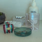 HÔTEL827 pink glass storage jar on vanity holding cotton butts and accessories