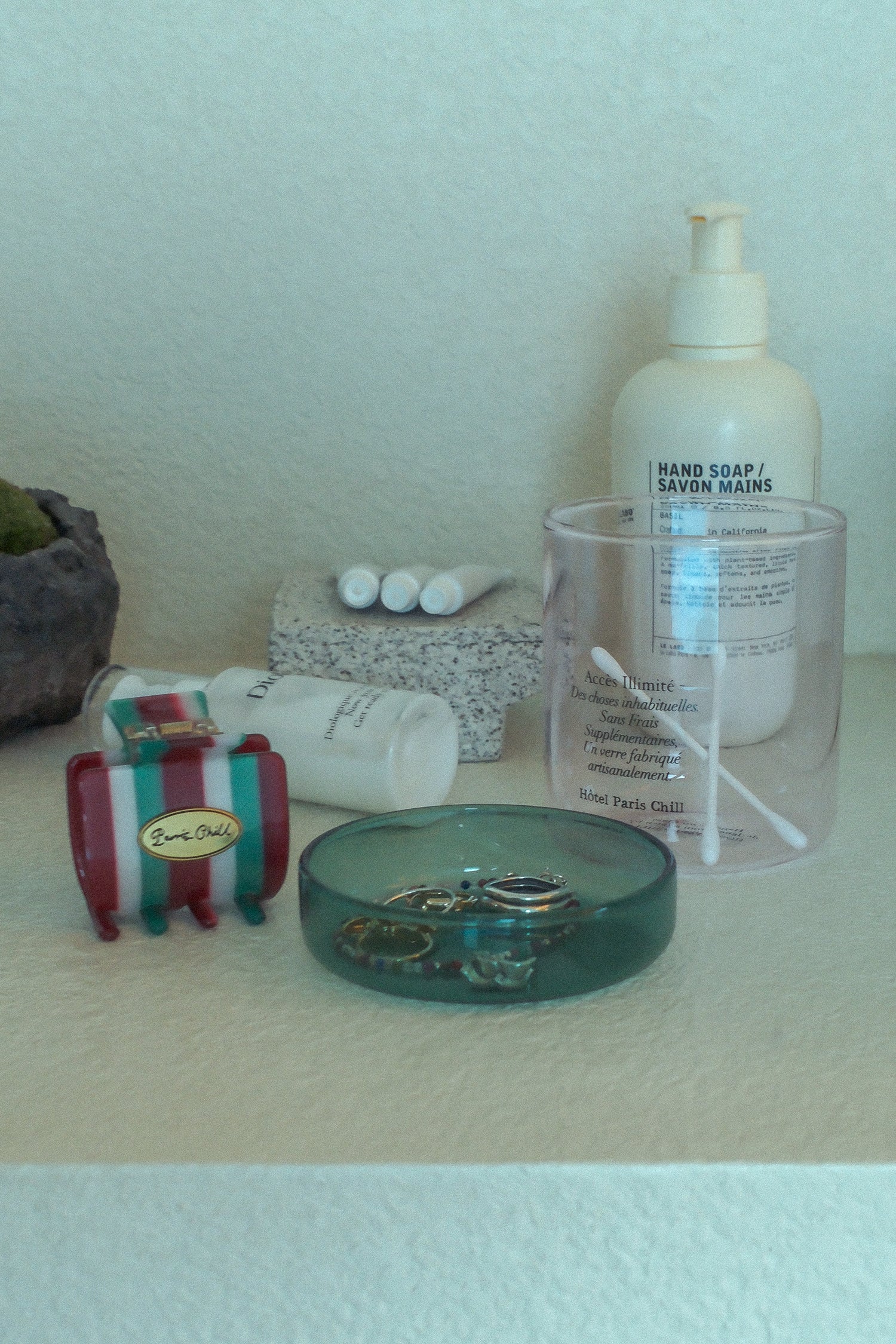 HÔTEL827 pink glass storage jar on vanity holding cotton butts and accessories